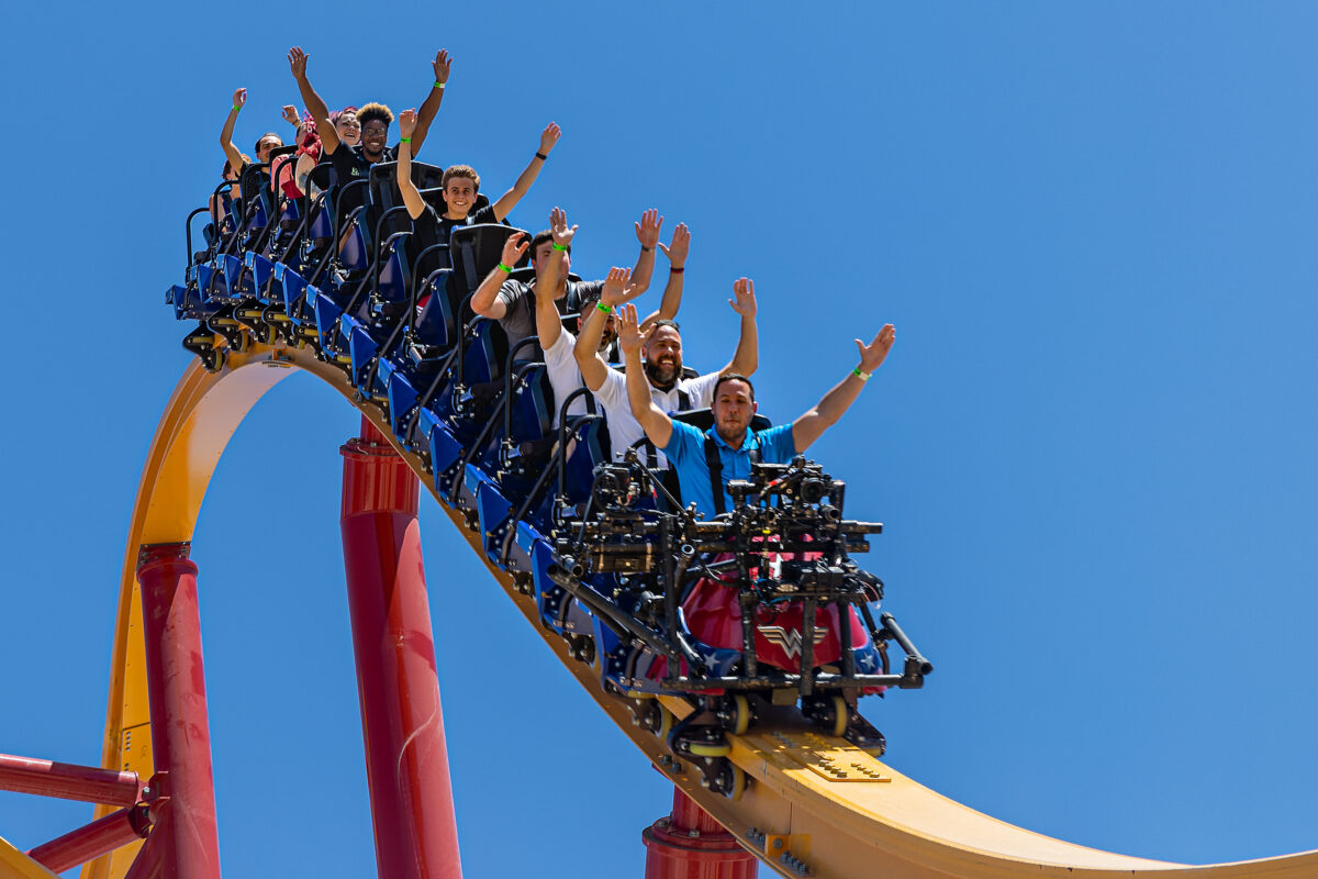 Roller coaster riders secured in over-the-shoulder restraints during a high-speed section of a ride