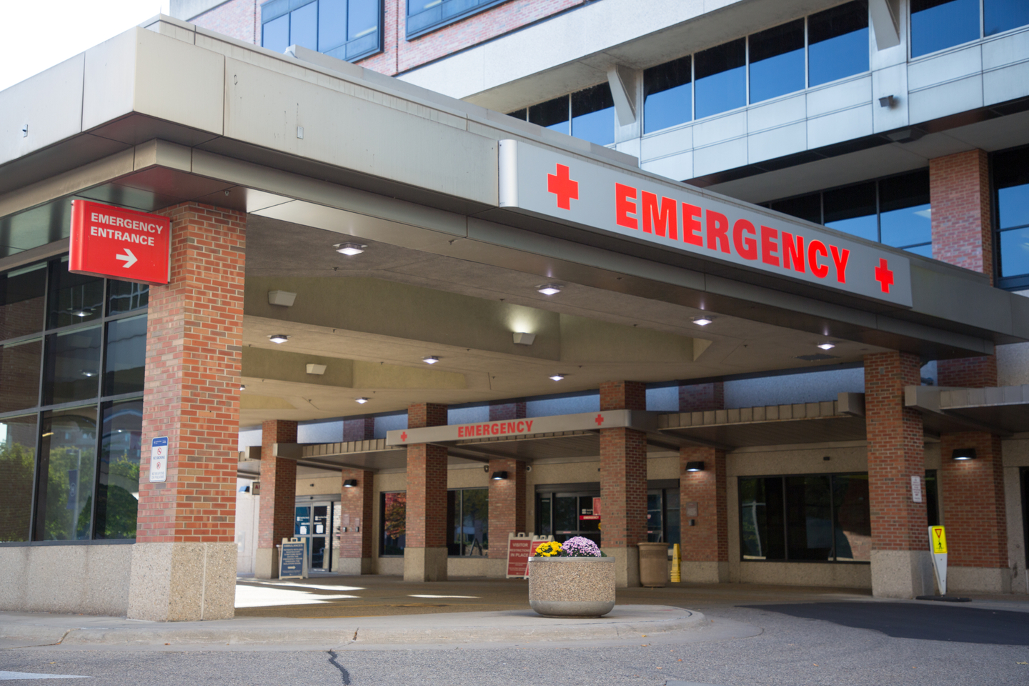 The exterior entrance of a hospital emergency department at night with ambulance bay lights on